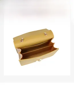 Top view of yellow crossbody bag showing internal compartments and golden metal M hardware