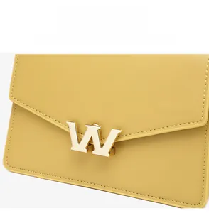 Close-up of bright yellow PU leather crossbody bag featuring a gold W-shaped metal buckle