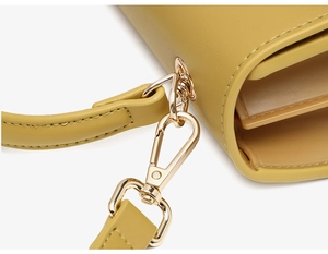 Detail of yellow PU leather bag featuring light gold metal buckle and precise stitching
