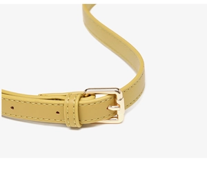 Detail of mustard yellow leather shoulder strap with golden buckle and fine stitching