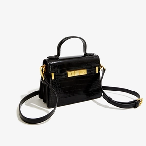 Détail de la texture effet crocodile et du fermoir doré sur le sac à bandoulière noir
