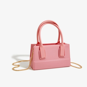 Detailed view of pink PVC jelly handbag with golden chain strap and double handles