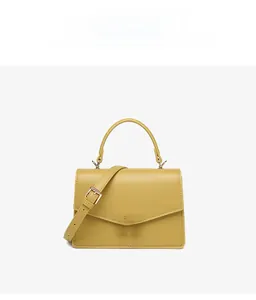 Detail of yellow PU leather crossbody bag featuring gold metal W-logo and V-flap design