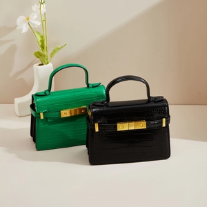 Détail de sacs à main en cuir crocodile avec d'élégants fermoirs rotatifs dorés