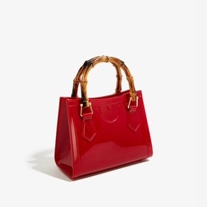 Detailed macro view of the natural bamboo handle and shiny red patent leather texture