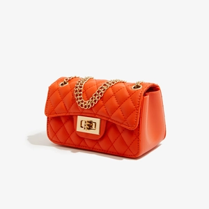 Detail view of the quilted orange PU leather texture and gold metal twist lock