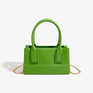 Detail view of bright green PVC jelly bag with sleek texture and golden chain strap