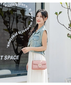 Pink quilted crossbody bag with gold chain strap worn by a model in casual outdoor setting