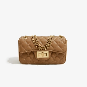 Close-up of beige quilted PU leather crossbody bag with gold-tone metal chain and twist lock