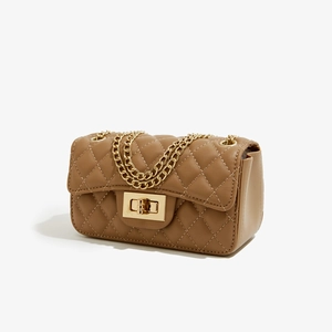 Detail of khaki quilted PU leather bag with gold chain strap and metal turn-lock closure