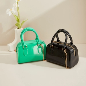 Détail des mini sacs Boston en PVC gelée vert et noir avec chaînes dorées élégantes