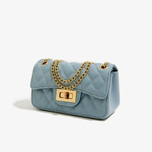 Detail of light blue quilted PU leather bag with gold metal chain and twist lock