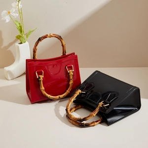 Detailed view of handmade bamboo handles and glossy patent leather on chic tote bags