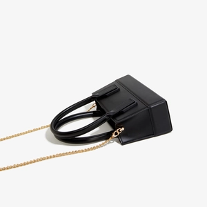Close-up of black matte PVC jelly bag with gold hardware and metal chain strap