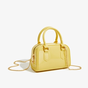 Vue détaillée du sac à main en PVC jaune brillant avec bandoulière dorée