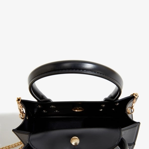 Detail view of the black PVC jelly bag featuring a golden magnetic clasp and chain strap