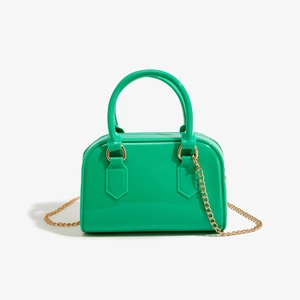 Détail du sac gelée en PVC vert citron avec une élégante bandoulière en chaîne dorée
