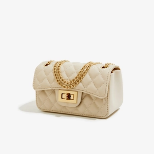 Detail of beige quilted faux leather bag with gold chain strap and square turn-lock closure
