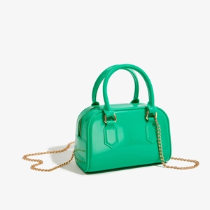 Gros plan d'un sac à main en PVC vert fluo avec fermeture éclair dorée et bandoulière