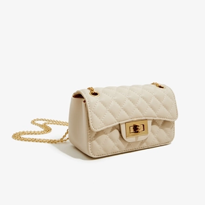 Detail view of cream quilted PU leather crossbody bag with golden twist lock and chain strap