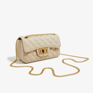 Detail of quilted PU leather flap bag with gold chain strap and metallic square turn-lock