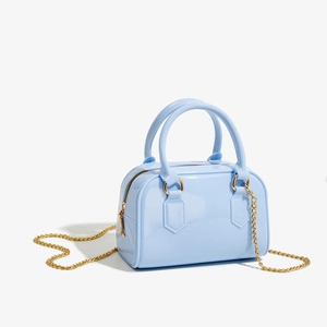Vue détaillée du sac gelée en PVC bleu clair avec finition brillante et chaîne dorée