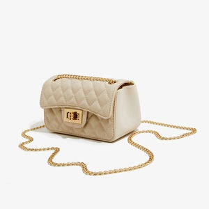 Close-up of cream white quilted PU leather texture with gold chain and turn-lock detail