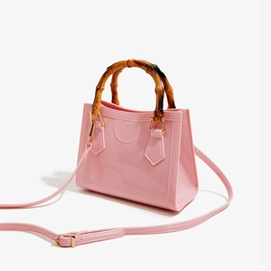 Detail of pink jelly bag with bamboo handle and adjustable shoulder strap on side