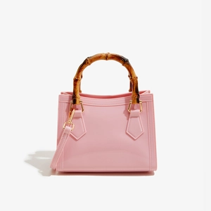 Detail of the pink PVC jelly bag showing bamboo handle and golden hardware loops
