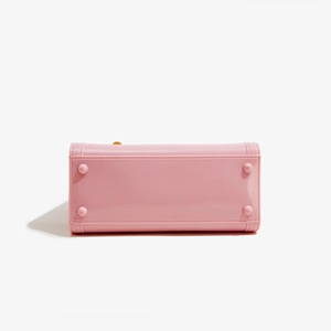 Pink jelly handbag base detail featuring protective studs and polished PVC texture