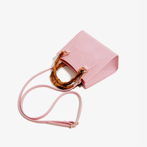 Macro shot of pink jelly handbag with vintage bamboo handle and glossy finish