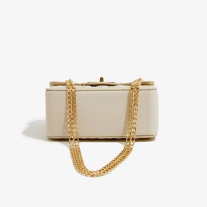 Detail view of cream PU leather crossbody bag with gold metal clasp and quilted texture