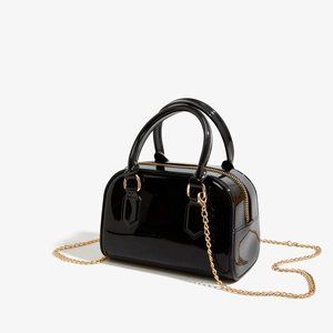 Vue détaillée du sac gelée en PVC noir brillant avec chaîne dorée et détails métalliques