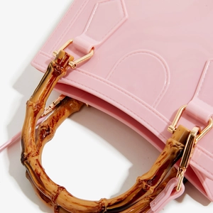 Detailed close-up of a pink jelly handbag featuring a bamboo handle and gold hardware