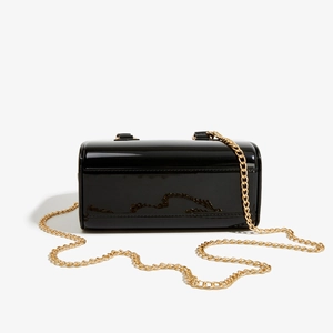Détail du sac barbie en PVC noir brillant avec chaîne dorée et poignée en cuir