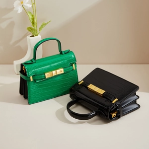 Sacs à main trapèze chic avec gaufrage croco en vert et noir et boucles métalliques dorées