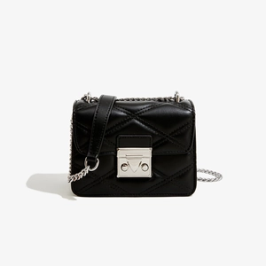 Détail de la boucle carrée argentée et matelassage en losange sur sac en cuir PU