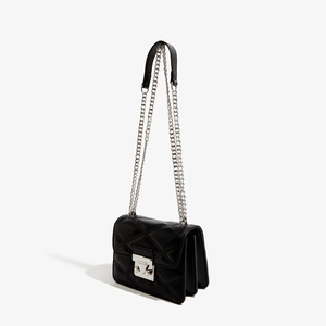 Détail d'un sac bandoulière matelassé en cuir PU noir avec chaîne et fermoir argentés