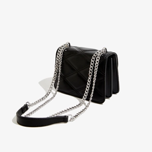 Détail du sac bandoulière noir matelassé en cuir PU avec chaîne argentée et côté accordéon