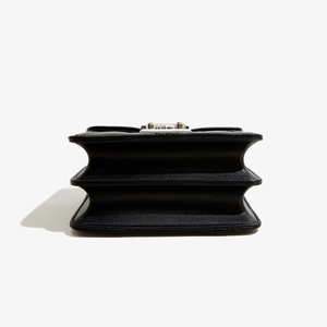 Détail du sac à main noir en similicuir avec structure en accordéon à trois compartiments
