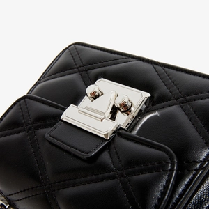 Détail de la texture en cuir noir matelassé et du fermoir en métal argenté du sac
