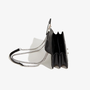 Détail du sac à bandoulière noir en cuir PU matelassé avec une conception à trois compartiments