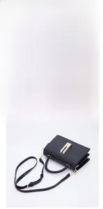 Detail view of black lychee leather crossbody bag with golden buckle and accordion design