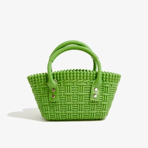 Detail der grünen geflochtenen PVC Tasche mit Textur und silbernen Metallnieten