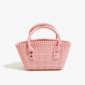 Detailansicht der rosa PVC-Flechtasche mit silbernen Nietverstärkungen für Damen