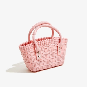Detailansicht der rosa geflochtenen PVC-Tasche mit Nieten und zylindrischen Griffen