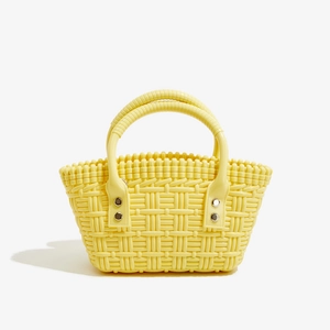 Detailansicht der gewebten gelben PVC-Tasche mit Metallnieten und rundem Griffdesign