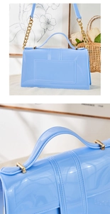 Détail du sac à main bleu clair verni avec accessoires dorés et bandoulière en chaîne