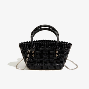 Makrodetail der schwarzen geflochtenen PVC-Gelee-Tasche mit glänzendem Finish und Silberkette