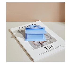Detail of light blue PVC jelly handbag featuring matte finish and curved top handle